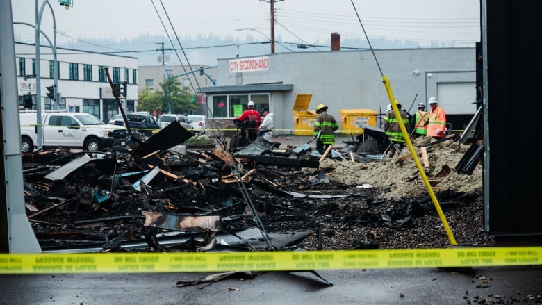 Crews sift through rubble in the aftermath of an explosion and fire.