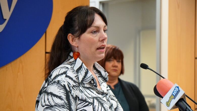 A woman speaks into a microphone.