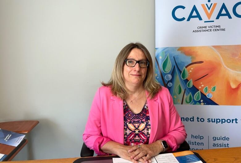 Woman at a desk in front of a sign about crime victims.