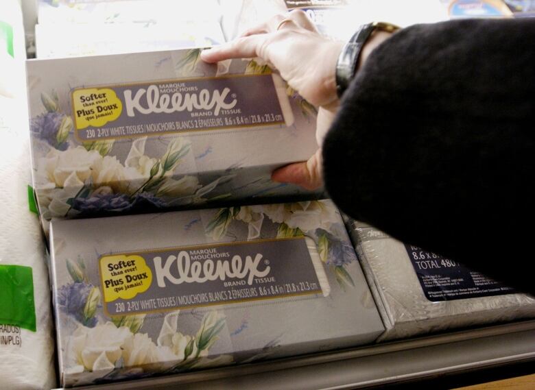 A woman reaches for a box of Kleenex