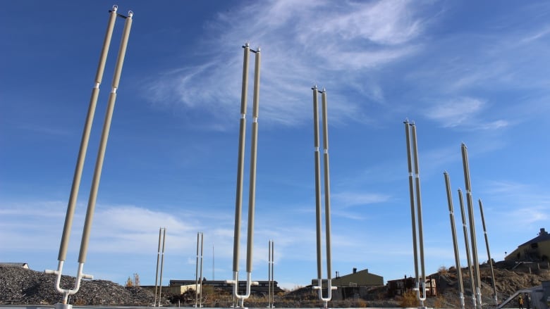 Long rods reaching high into a blue sky.