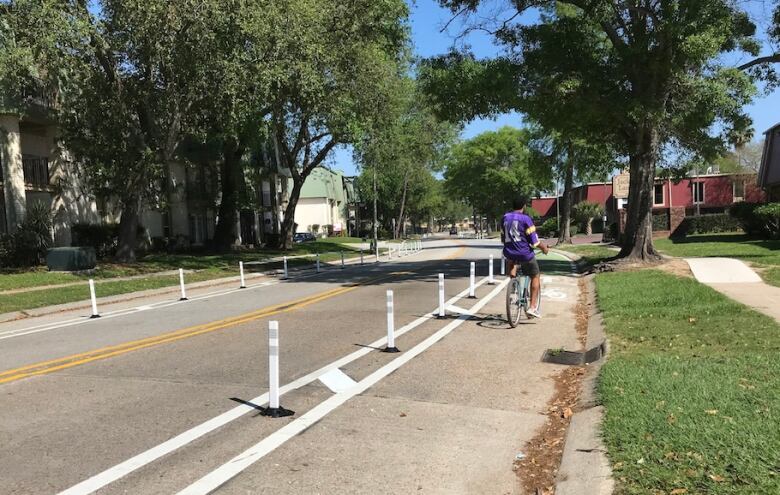 A road with a bike lane and a cyclist on it