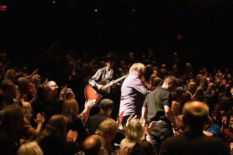 Theater audience watching a musician.