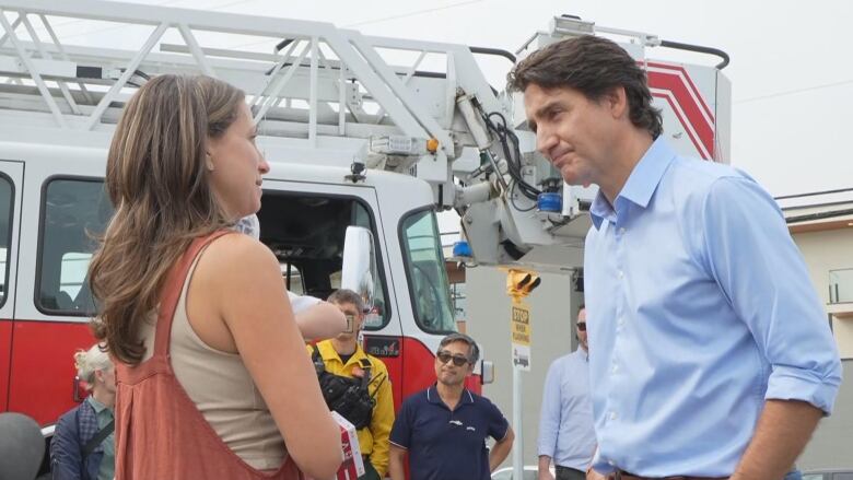 Trudeau speaks to a woman outside a fire hall.