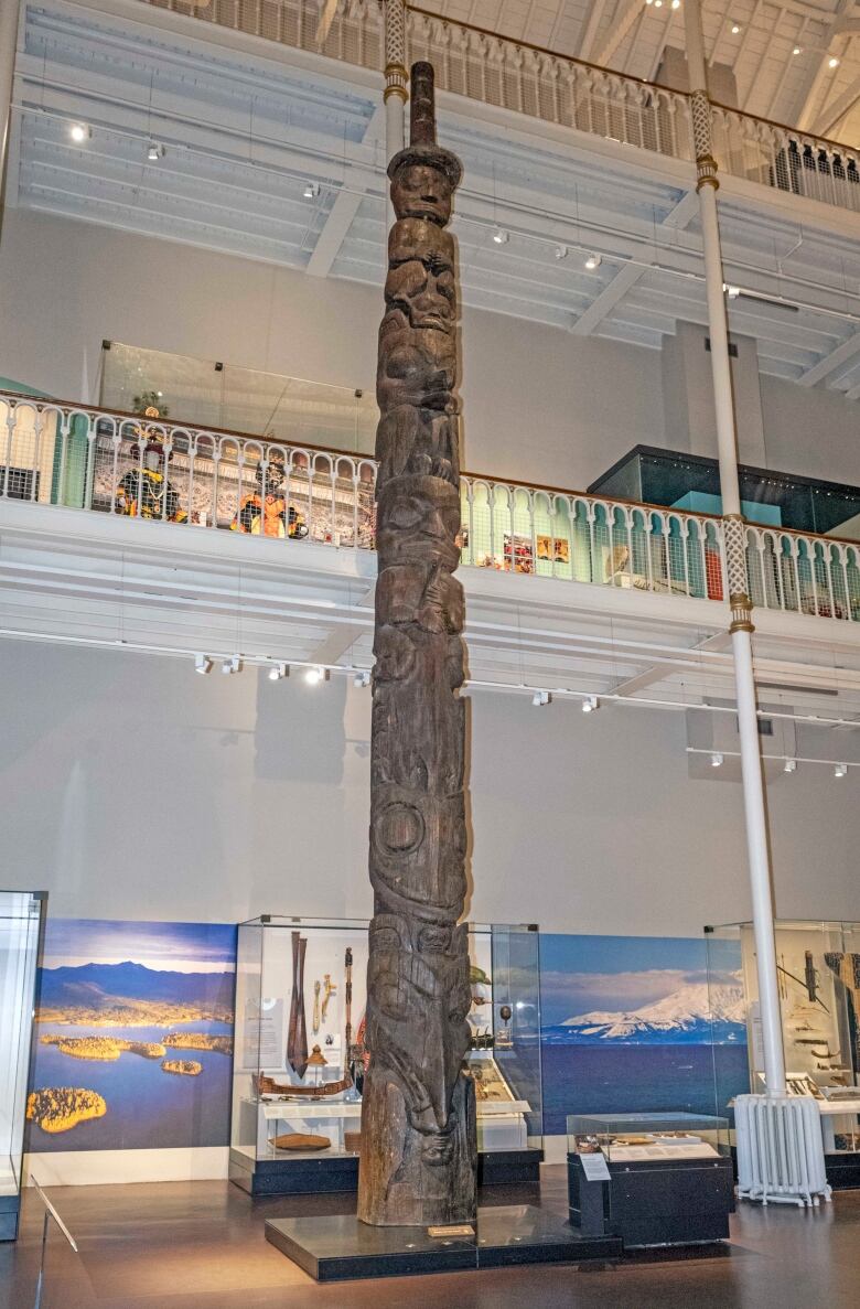 A giant totem pole is pictured in a museum.