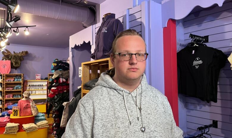 A man poses for a photo in a shop with purple walls.