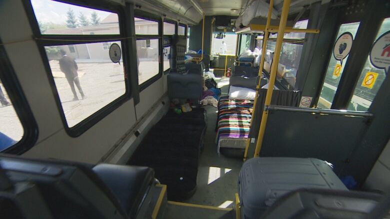 A bus with blow up mattresses on the floor.