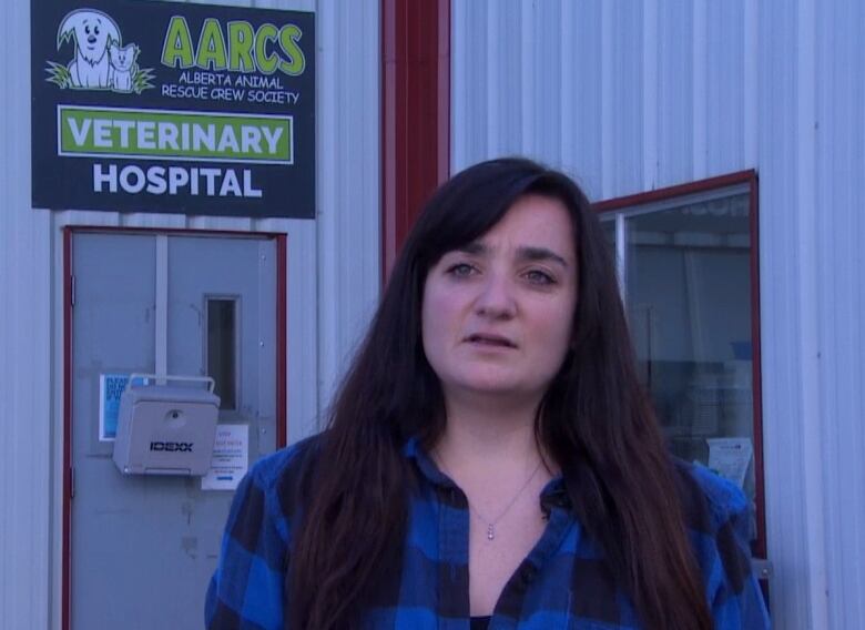 A woman wearing a blue checked shirt is seen in the photo.