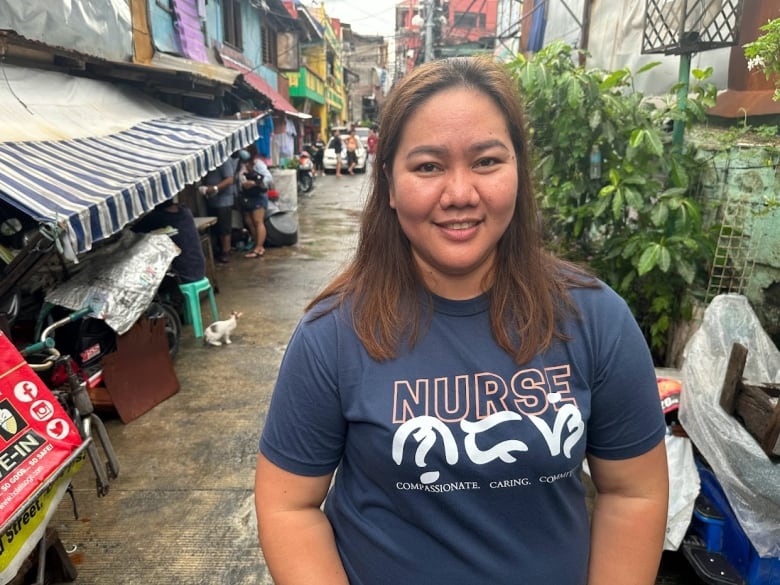 A woman stands in a community in the Philippines