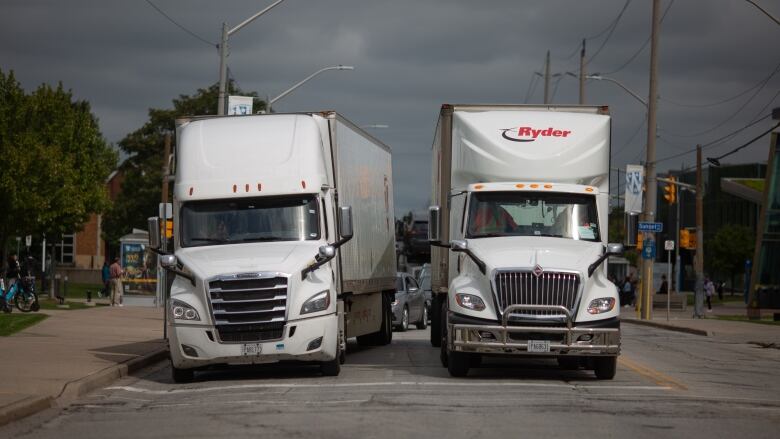 Two transport trucks on a roadway.