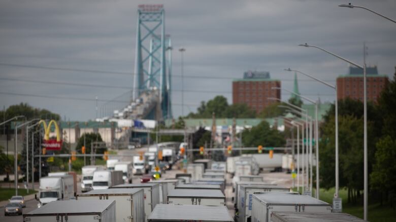 The tops of transport trucks and a blue bridge in the background.