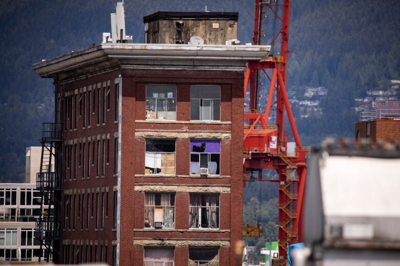 Air conditioners are seen in the windows of a brick low-income building in Vancouver.