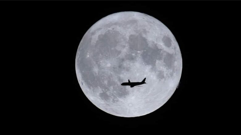 Airplane is pictured flying in front of the super blue moon Aug. 30, 2023. Picture is taken from video captured in Windsor, Ont.