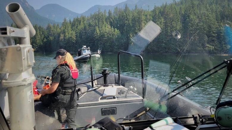 A DFO officer is on a rigid hulled inflatable boat, with another in the background.