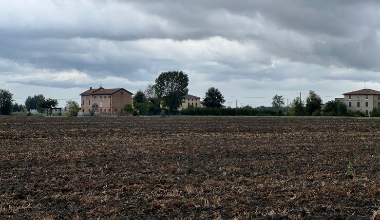 A few buildings are shown next to a field in northern Italy.