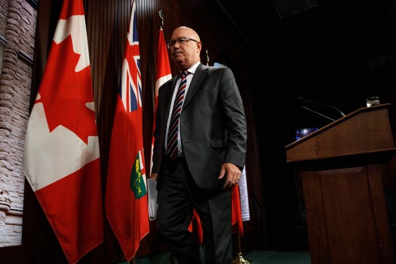 A man walks off a platform, away for a podium.