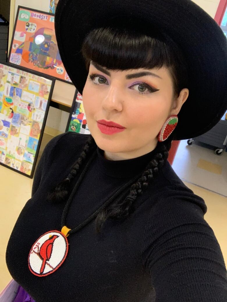 An Indigenous woman with a beaded medallion depicting a cardinal. 