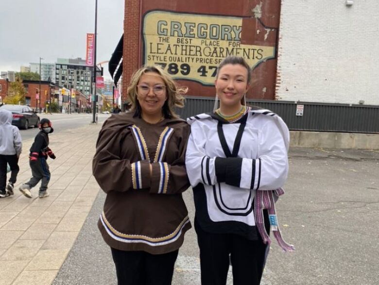 Two Inuit women wearing canvas parkas outside in Ottawa.