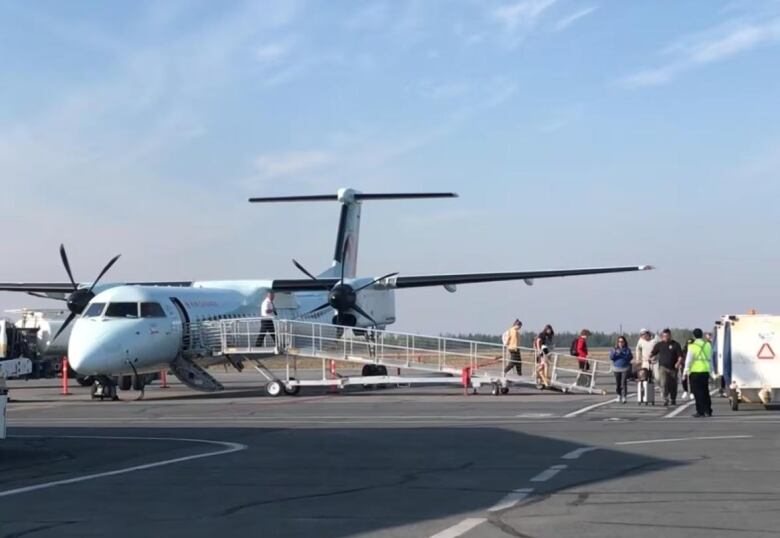 People walk off plane.