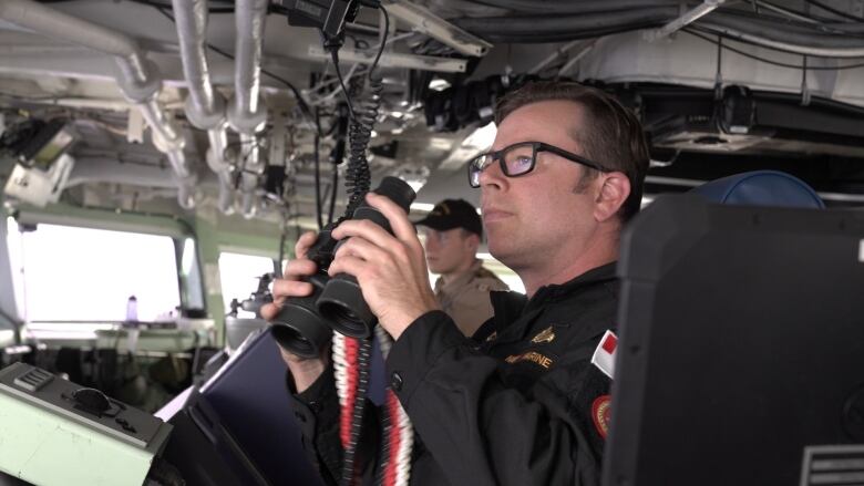 Cdr Samuel Patchell, Commanding Officer of HMCS Ottawa, watches a Chinese warship operating nearby.