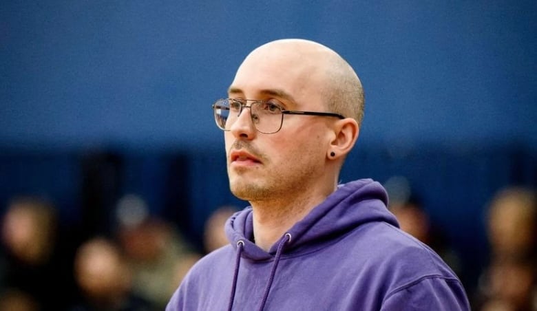 Man with glasses wearing a purple hoody.