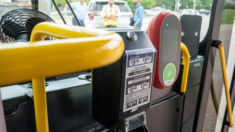 A red pay station on a bus.