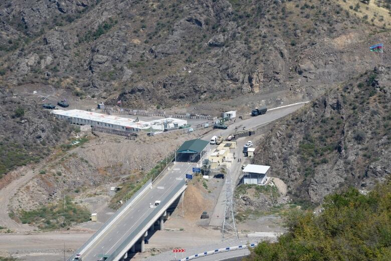 A road with a checkpoint in an arid mountain range