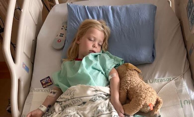 A young girl in a hospital bed. 