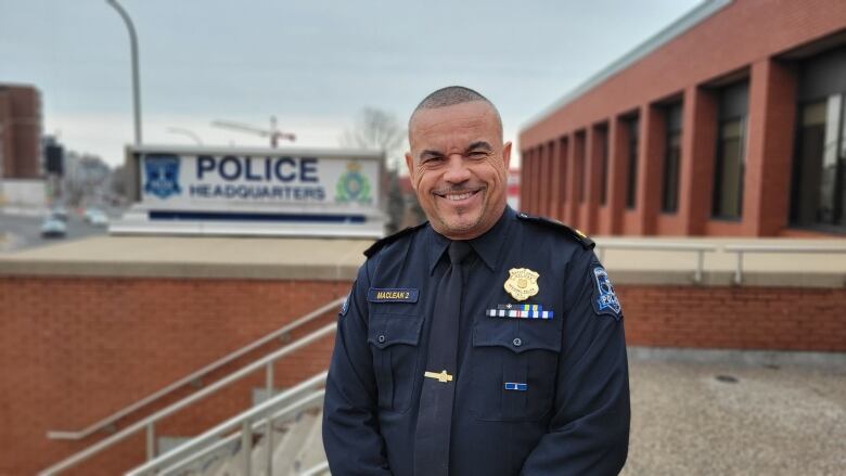 A man wearing a police uniform poses outside of Halifax Regional Police headquarters 