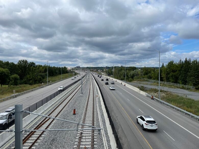 A highway on a weekend on a late summer weekend day. It has some vehicles on it, but isn't full.