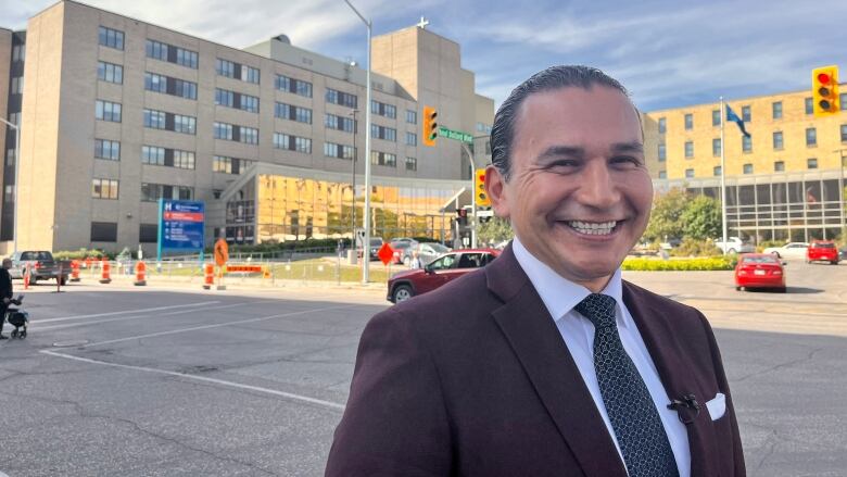 A man standing in front of a hospital.