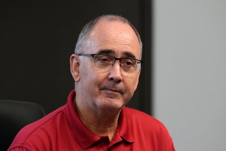 A man with glasses wearing a red shirt.