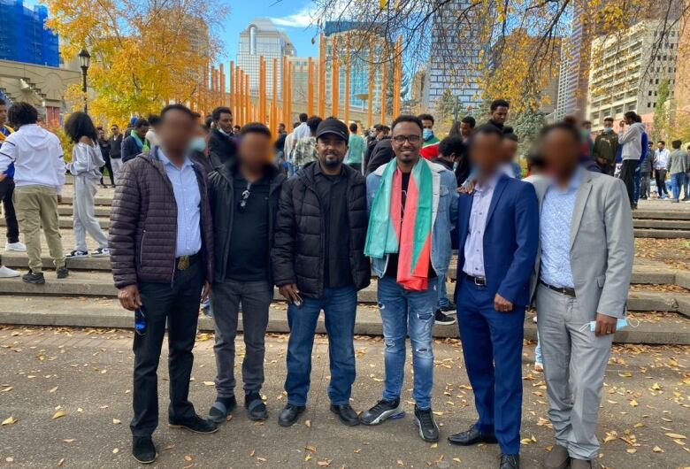 Six men stand near Calgary's city hall.