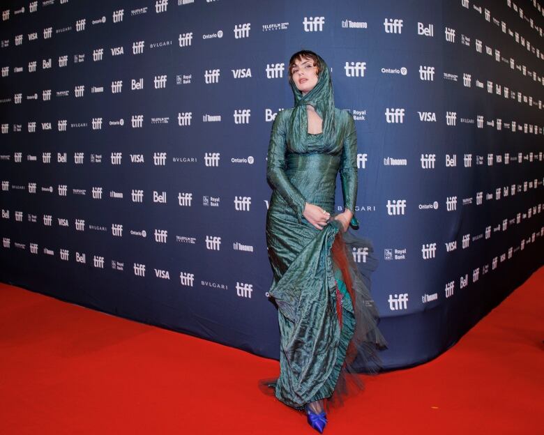 An actor in a green gown on the red carpet at TIFF.