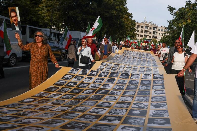 Protesters hold a banner in the street.