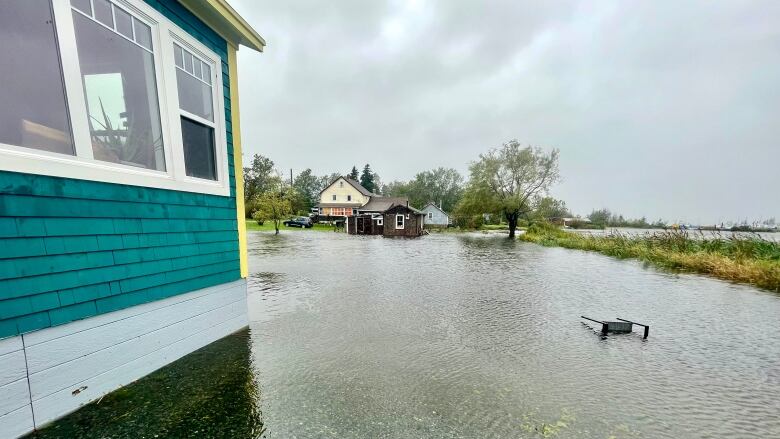 A flooded parking lot is shown with a turned over chair partially submerged.