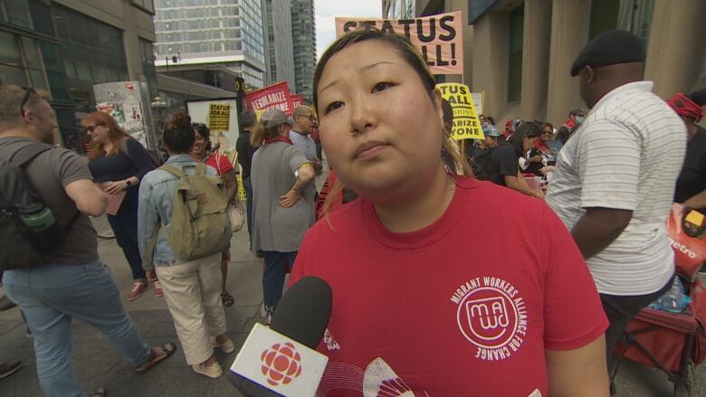 A person stands with a mic at a rally.