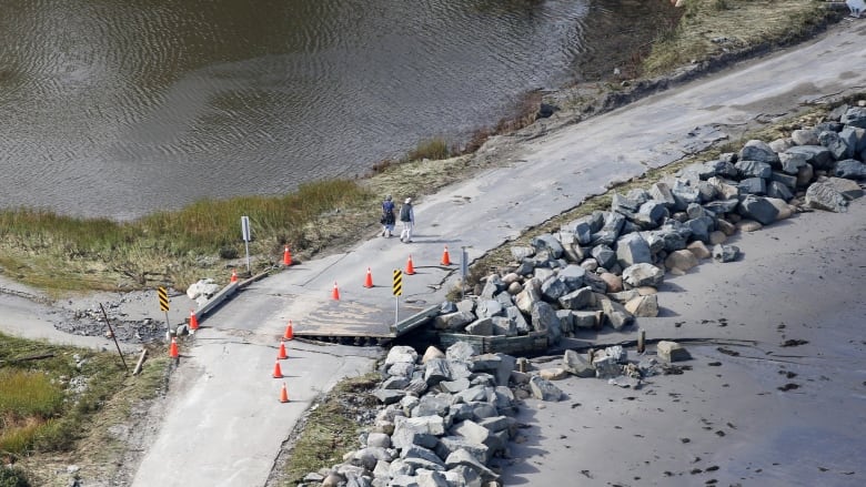 A damaged bridge with rocks on it.