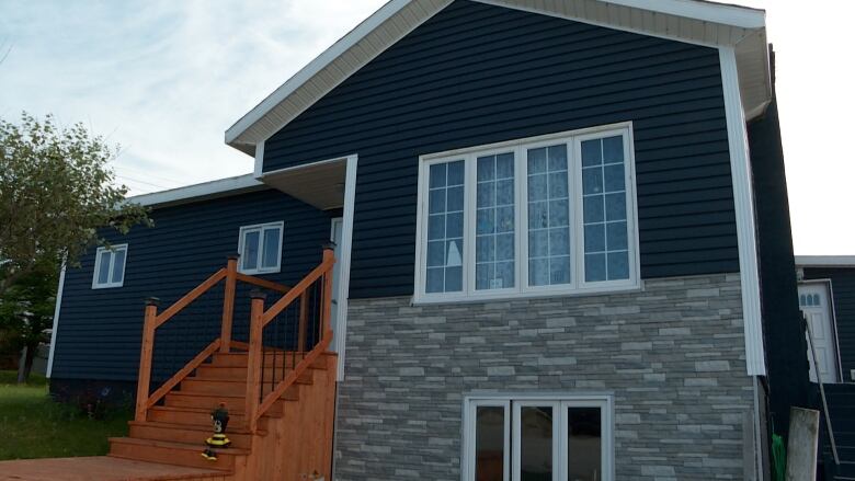 A blue home with grey bricks across the bottom.