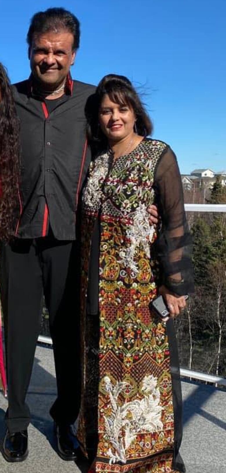 A man stands beside a woman on a sunny day.