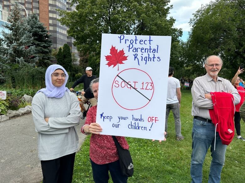 A woman holds a sign saying 