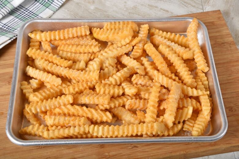 Freshly cooked frozen fries on a baking sheet.