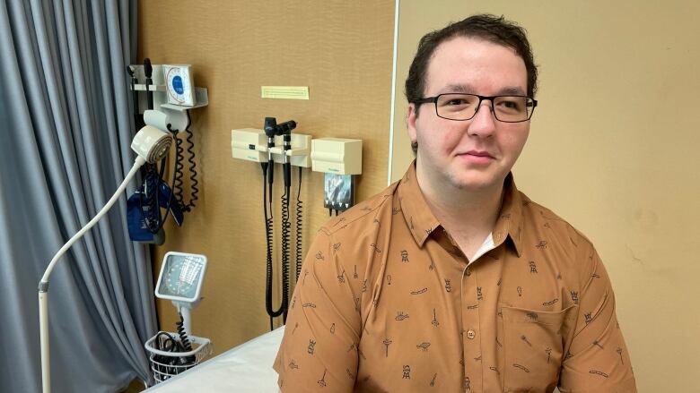 A man sitting in a medical examination room.