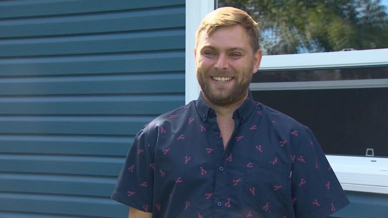 Bryson Bearden is a resident of Ashby. He stands in front of his newly built garage after Fiona destroyed the previous one.