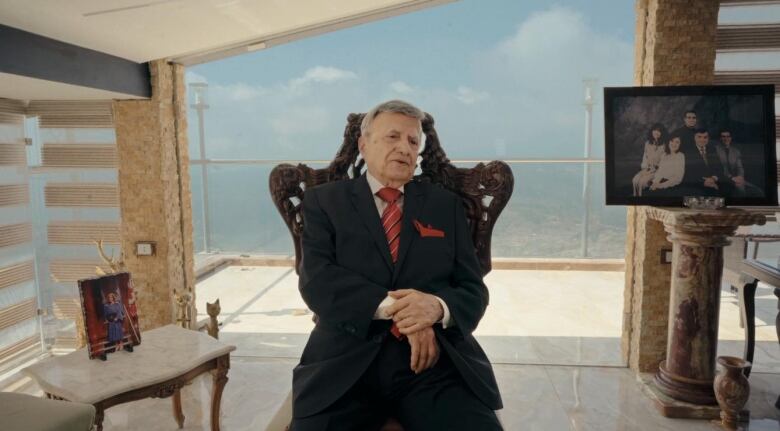 A man wearing a suit is pictured against the backdrop of a city.