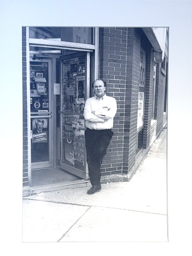 A framed portrait of a man outside a store.