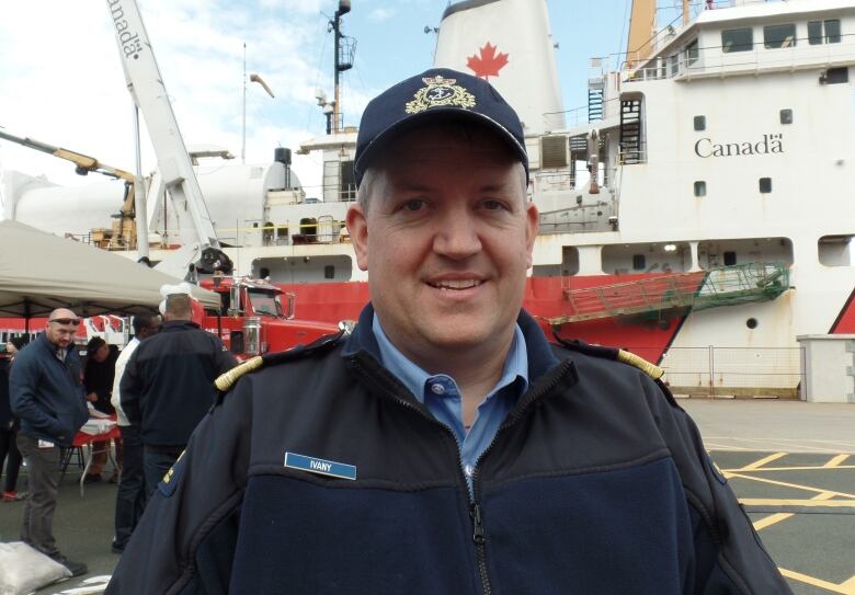 Man wearing a hat and behind him a ship.