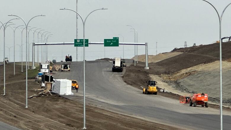 A road with multiple construction vehicles on it. 