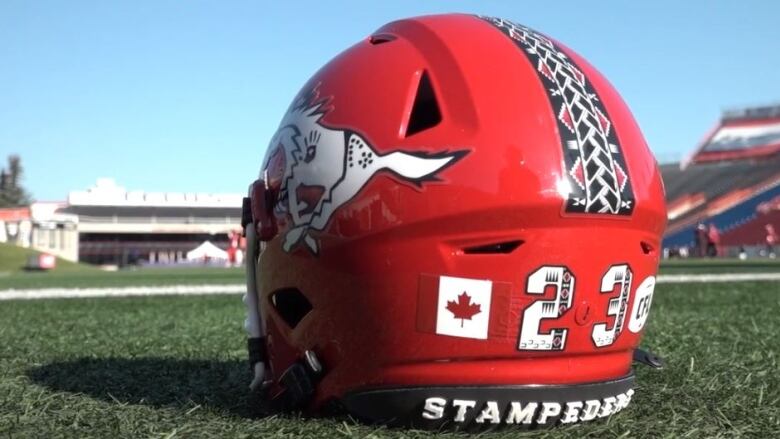 A red helmet sits on green turf. 