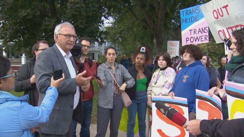 Premier Blaine Higgs meets with people outside.